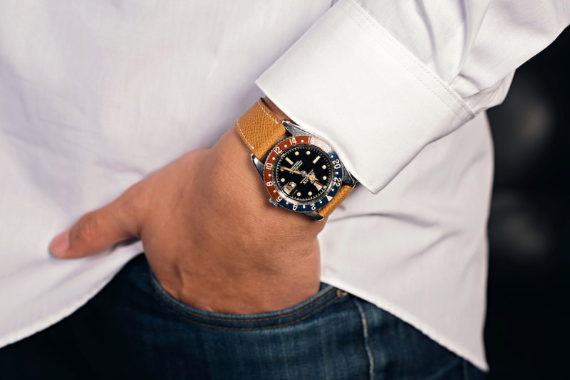 Man in white shirt with a Rolex watch and hand in pocket