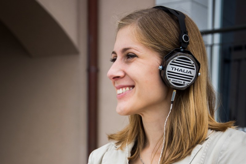 woman listening to podcast and smiling