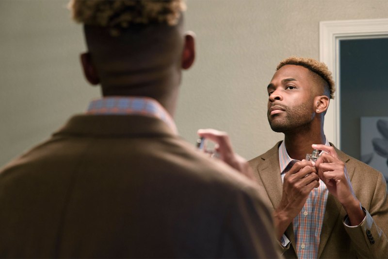 Man putting on cologne