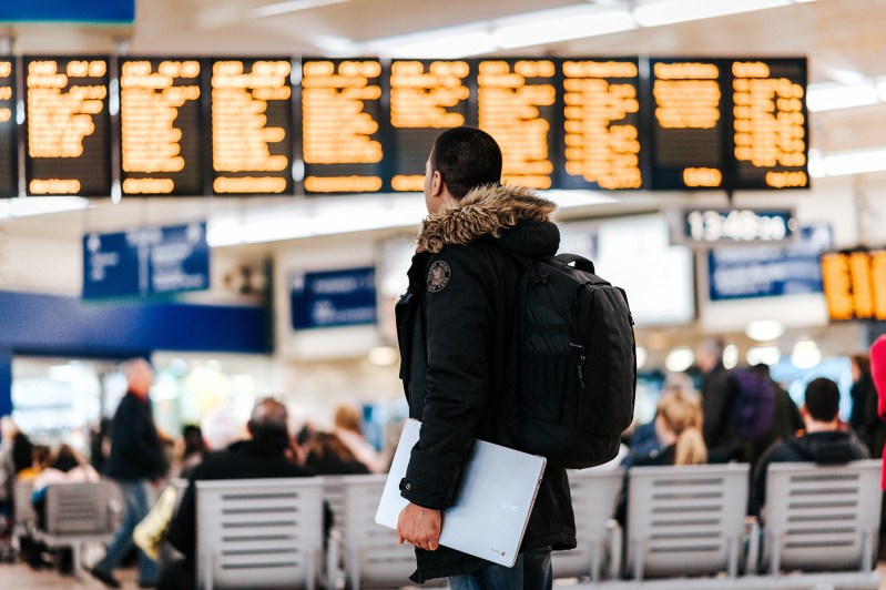 A person in the airport looking at the flight board.