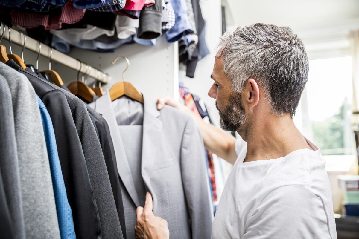 Man choosing clothes at his walk-in closet