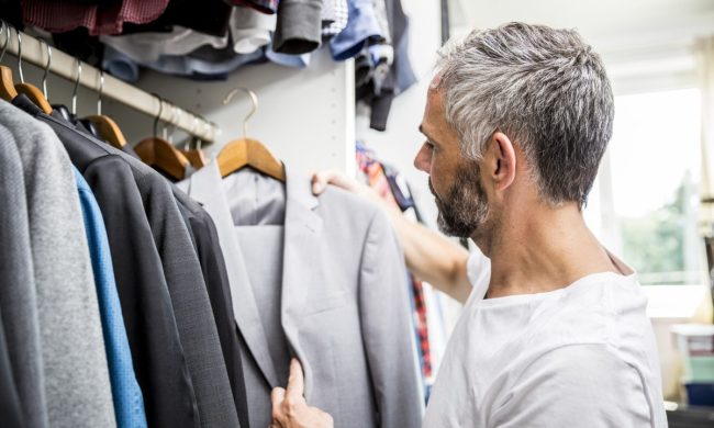Man choosing clothes at his walk-in closet.
