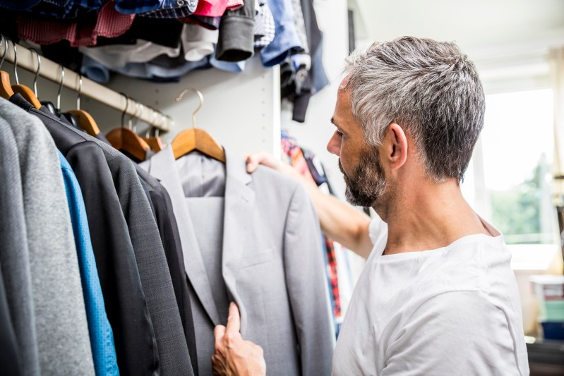 Man choosing clothes at his walk-in closet