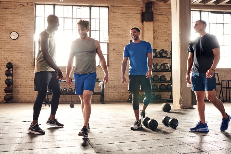 Men at the gym, seemingly having a conversation.