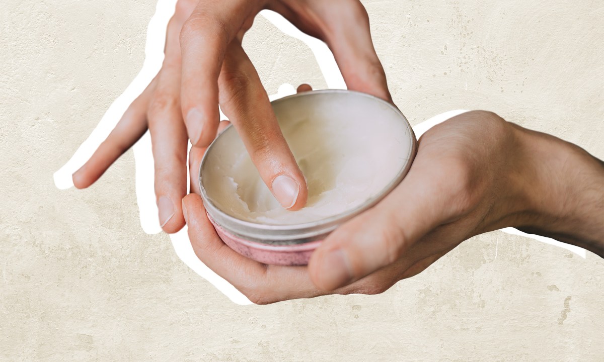 A pair of hands using beard balm.