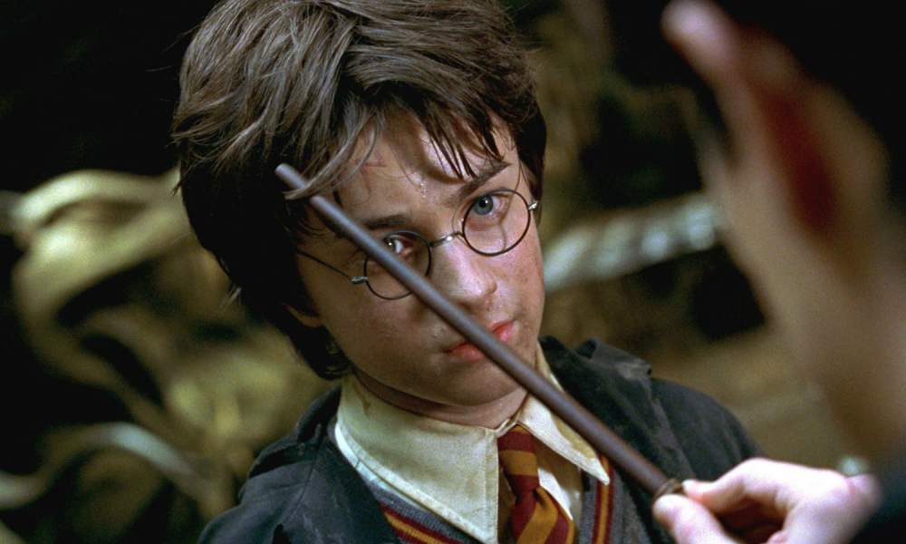 Harry Potter holding a wand and looking disappointed.