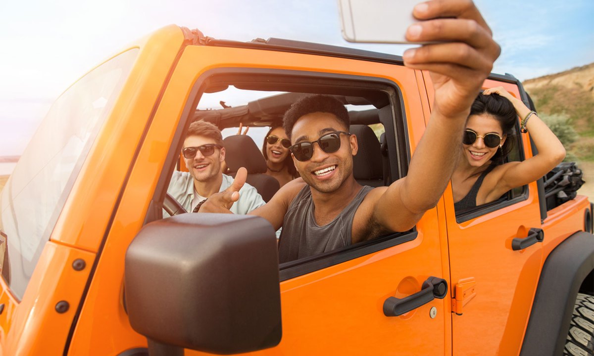 people in an orange car during a road trip