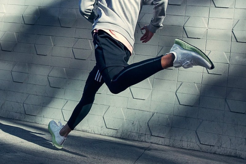 A man running with his pair of athletic sneakers.