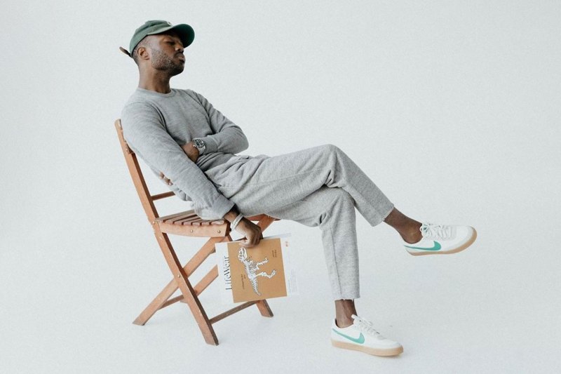 Man wearing Uniqlo clothing, sitting in a chair.