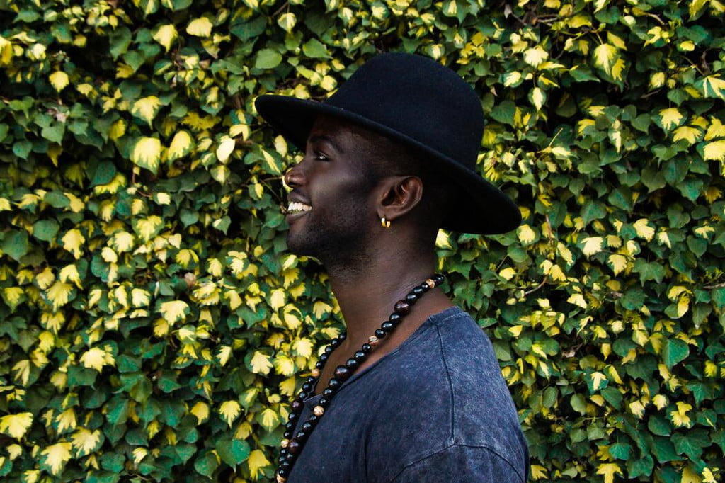 Man wearing earrings as part of his outfit.