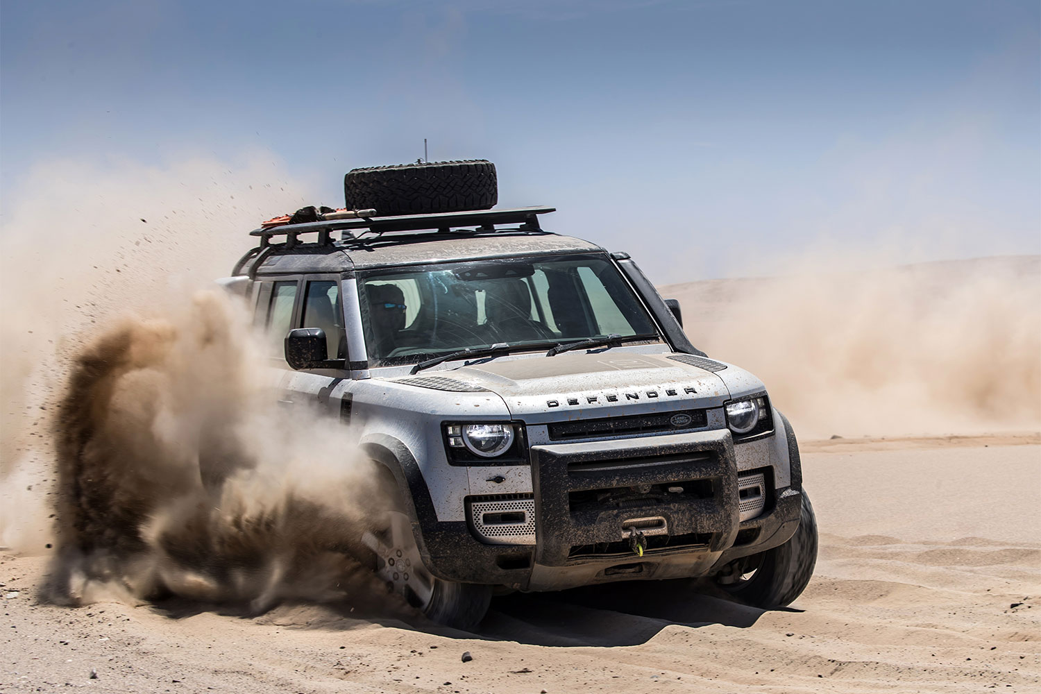 Land Rover Defender hitting a sandy trail.