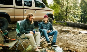 Two men in camping chars by a campfire