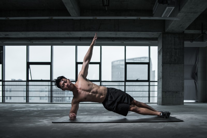 A man exercising with his yoga mat.