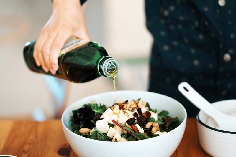 Pouring olive oil in a salad