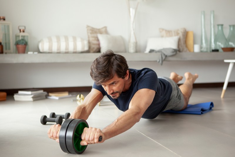 Man using an ab roller at home