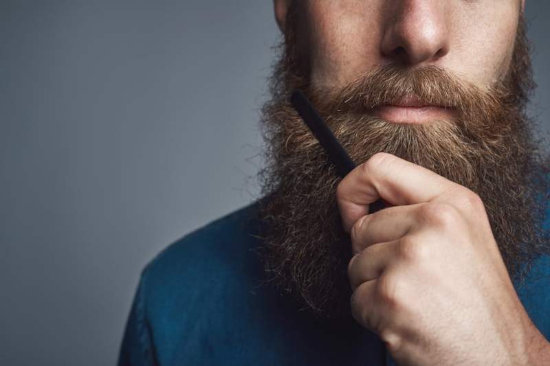 Man combing his beard.