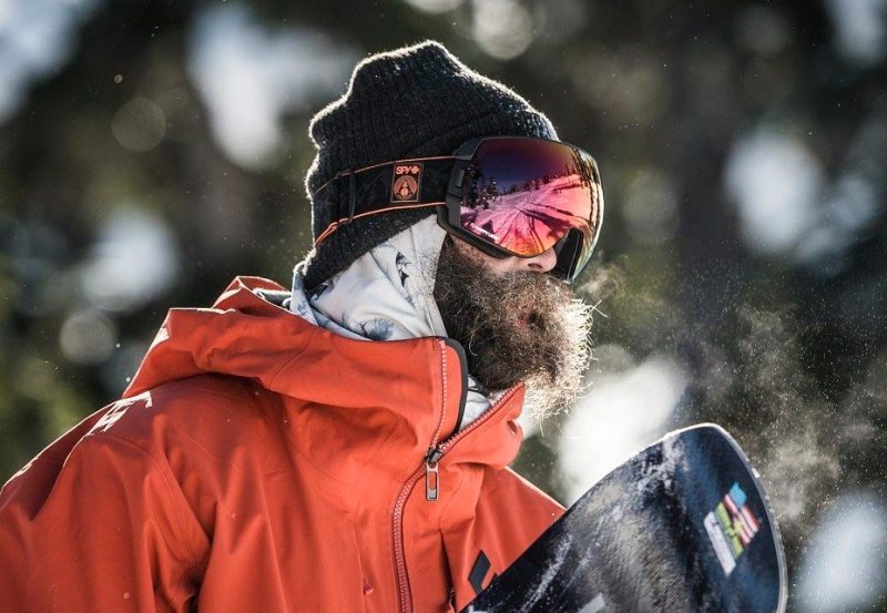 Snowboarding man wearing Spy Optic Snow Goggles.