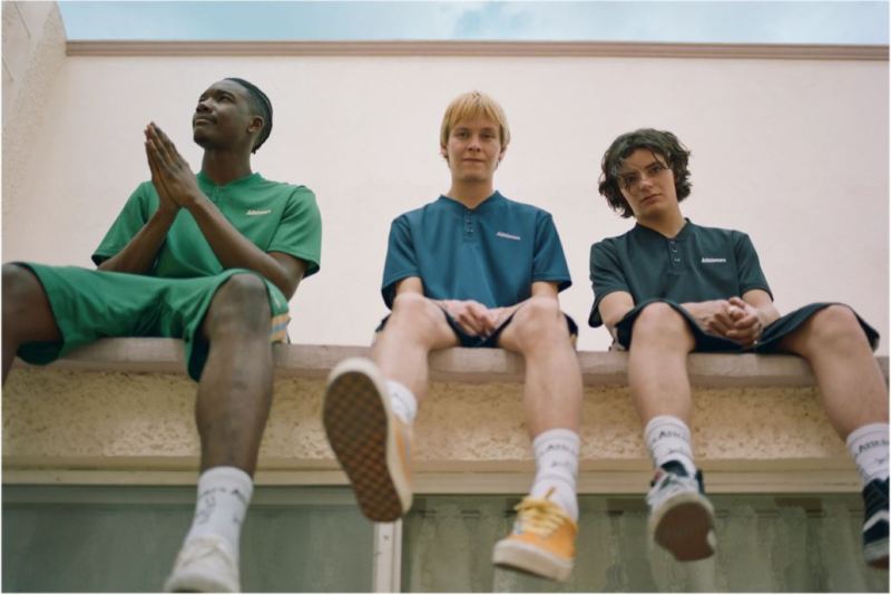 Three guys sitting on ledge