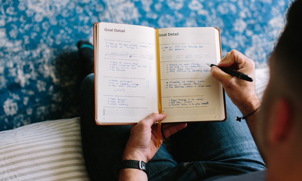 person writing in their planner.