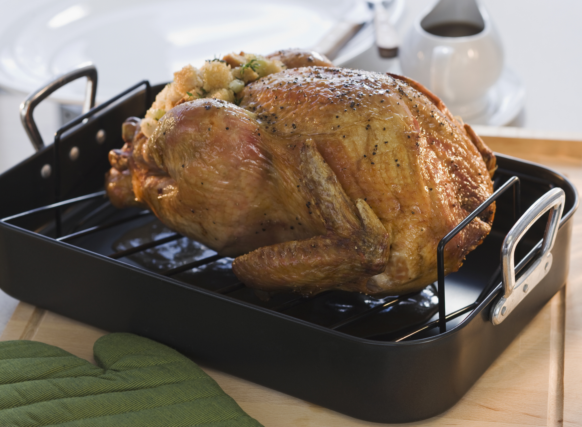 Cooked turkey in a roasting pan displayed on a counter.