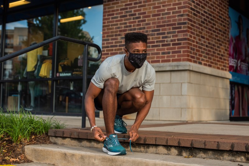 Man tying his shoes and preparing to run.