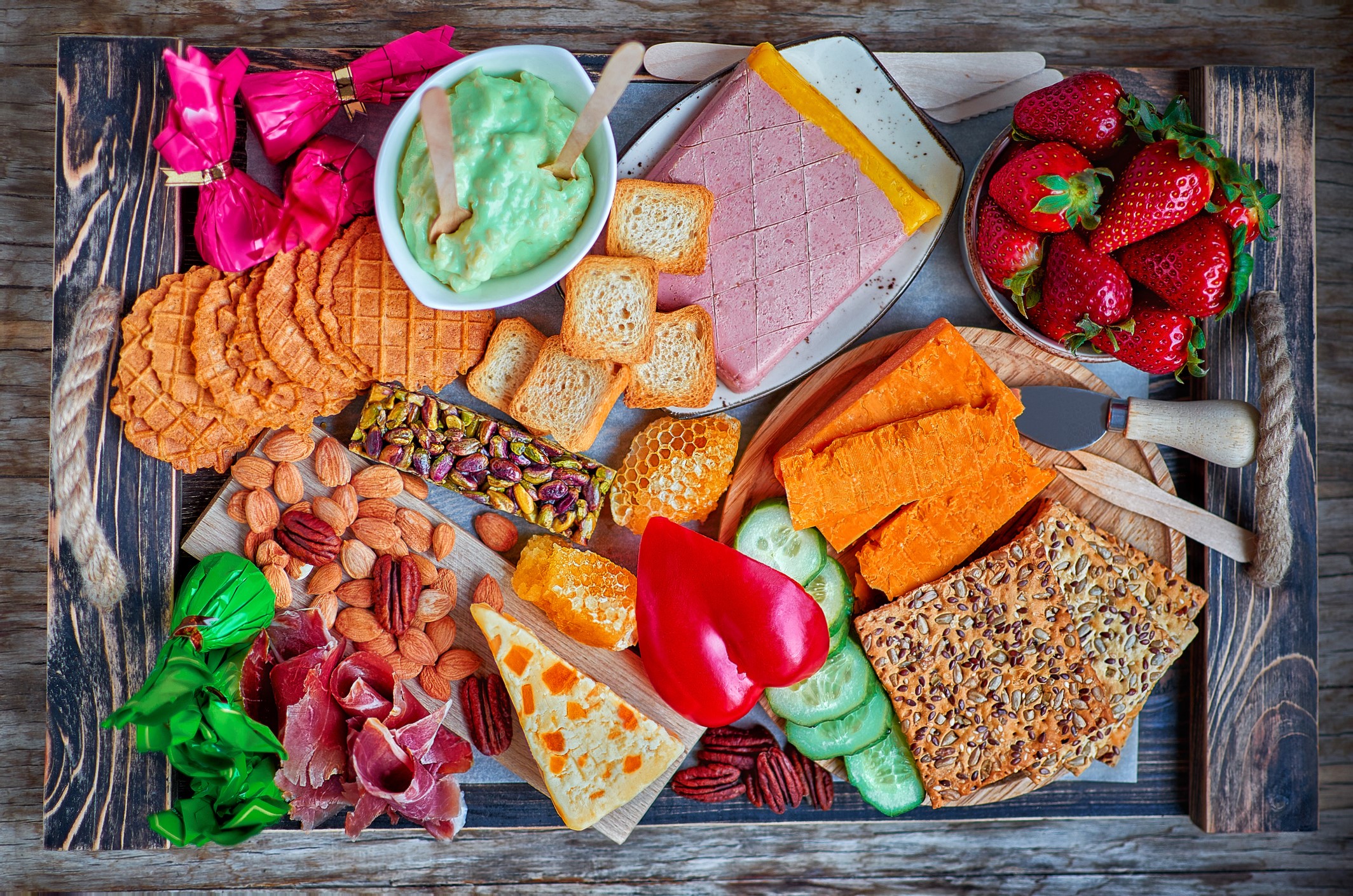 Charcuterie board with avocado dip, Leicester cheese, Wensleydale cheese, honey, cucumber, and more