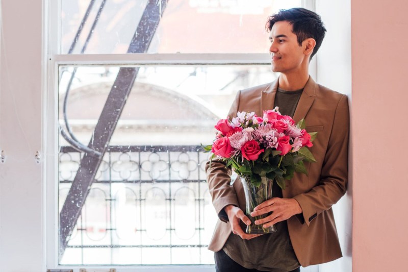 Man holding a bouquet of flowers.