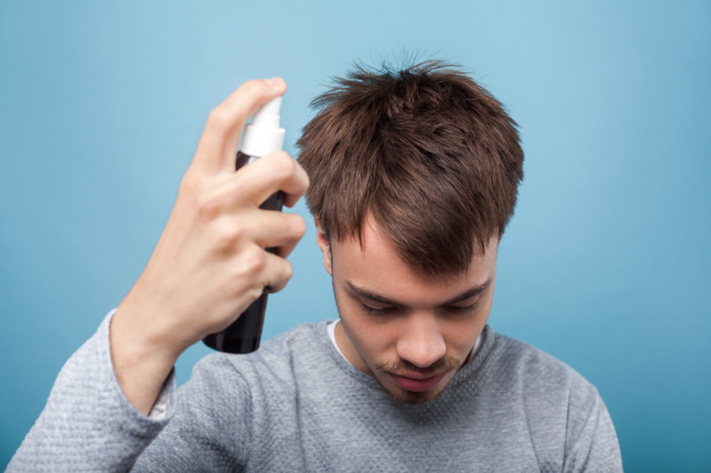 Man spraying his hair