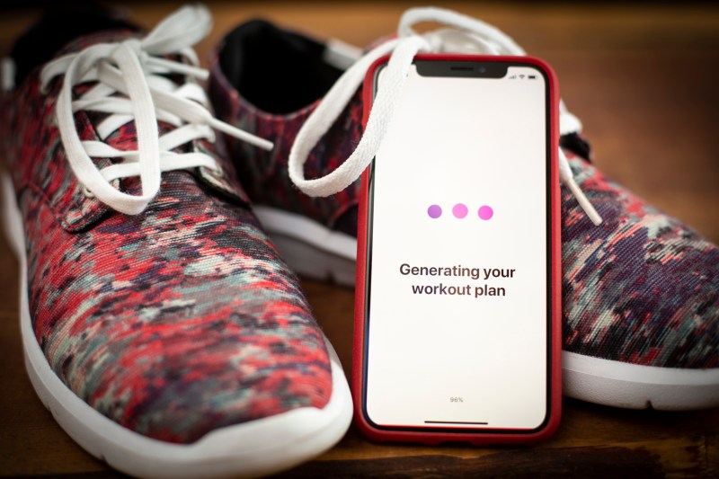 Workout app on a phone with running shoes