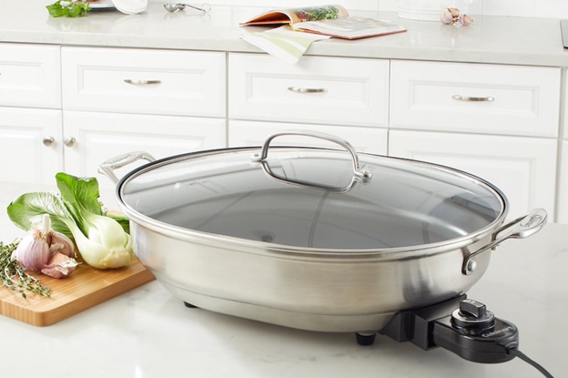 Stainless electric skillet on a kitchen countertop.