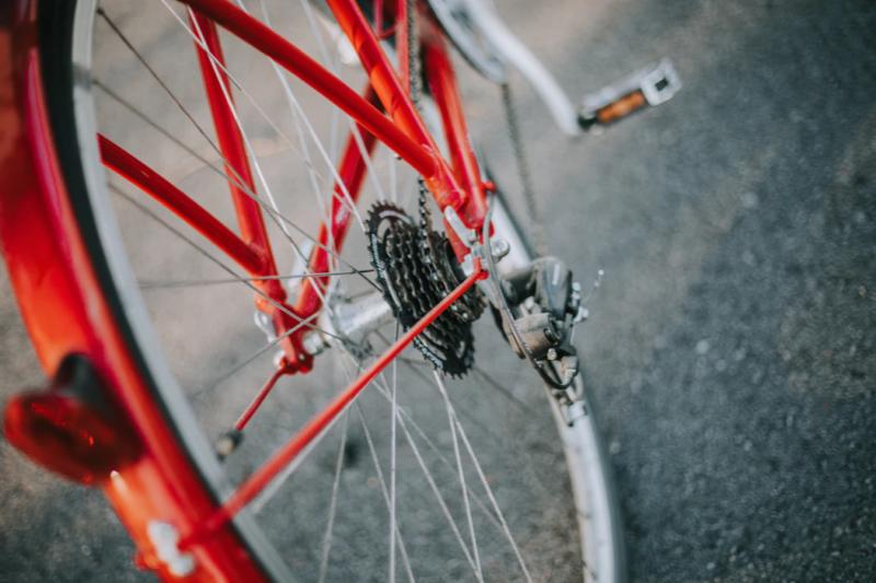 The rear wheel of a bike showing the gears and chain.