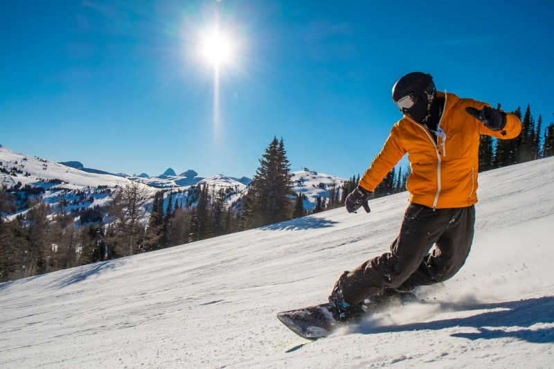 Snowboarder cranks turn on mountain slope