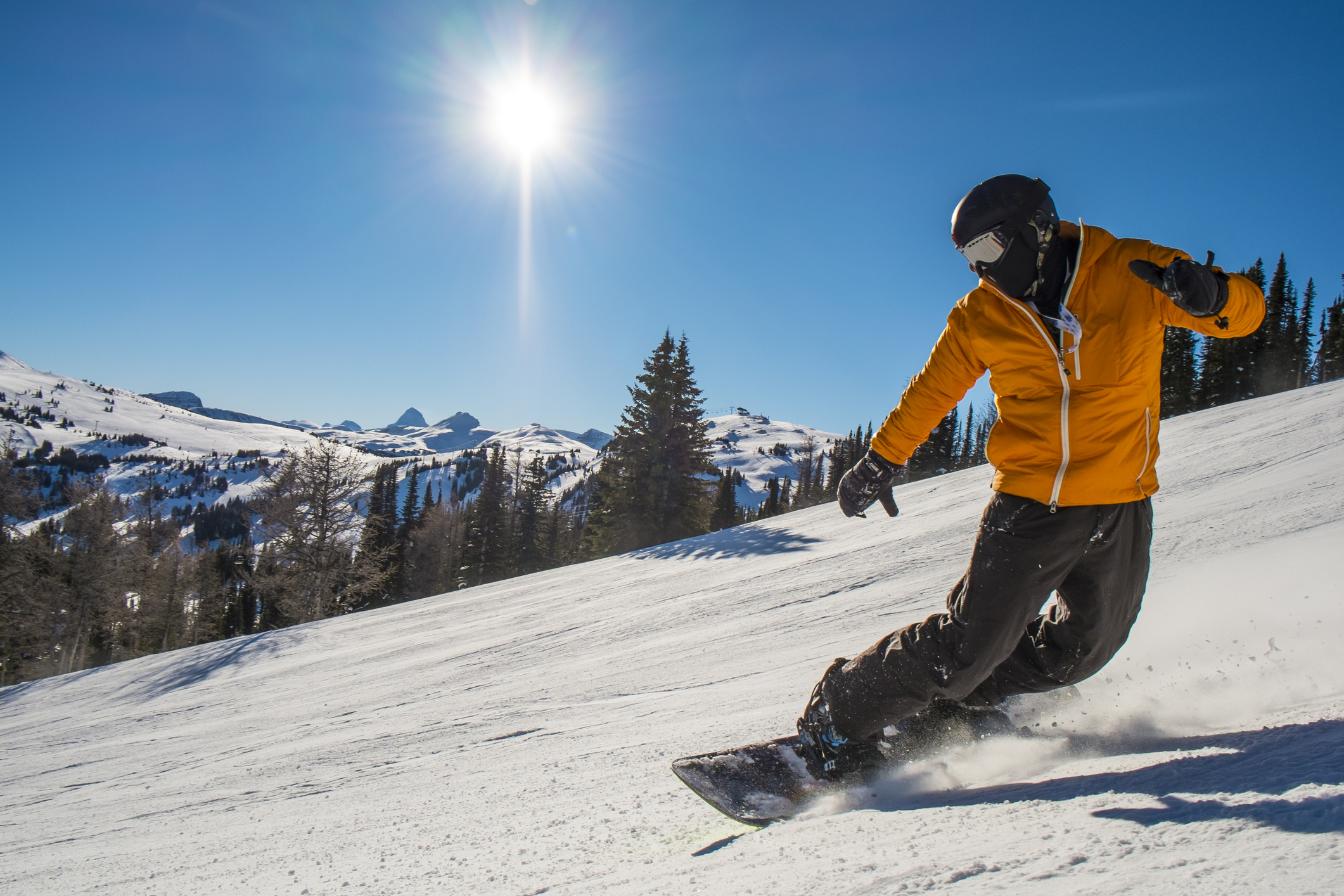 Snowboarder cranks turn on mountain slope