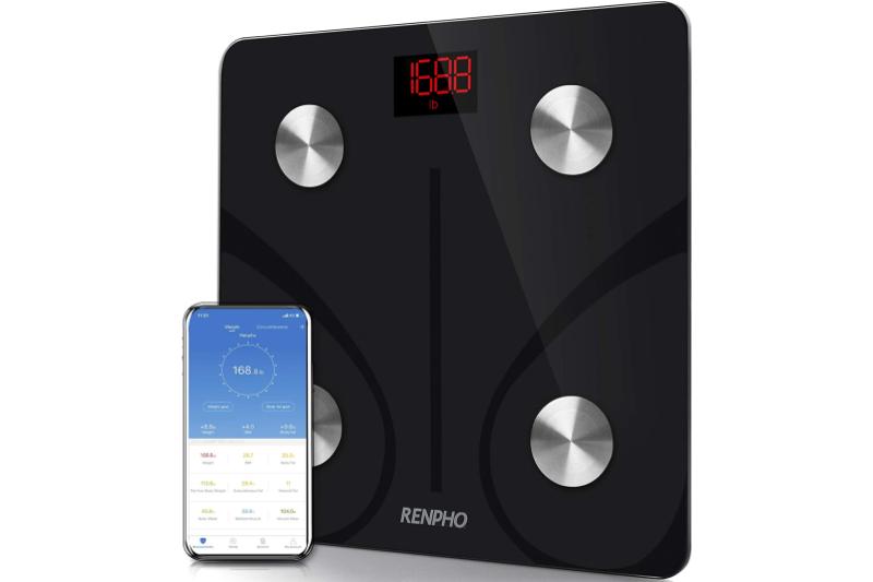 A Renpho body fat smart scale stands upright next to a phone with the Renpho smart app on its screen.