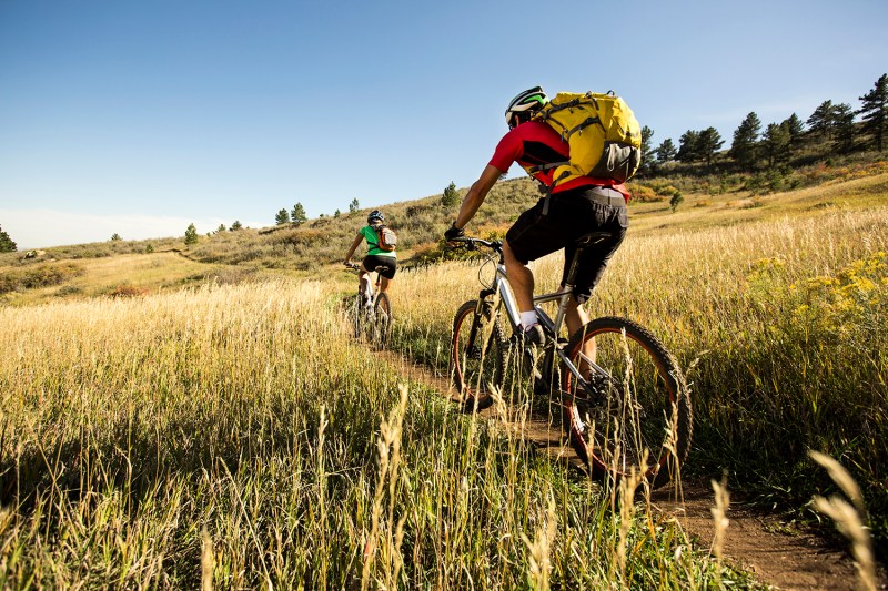 Man and woman biking on a dirt path