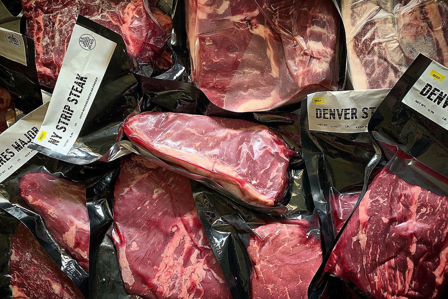 packaged steaks in a pile.