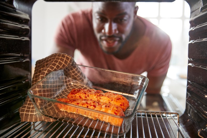 View looking out from Inside oven as man cooks oven-baked salmon