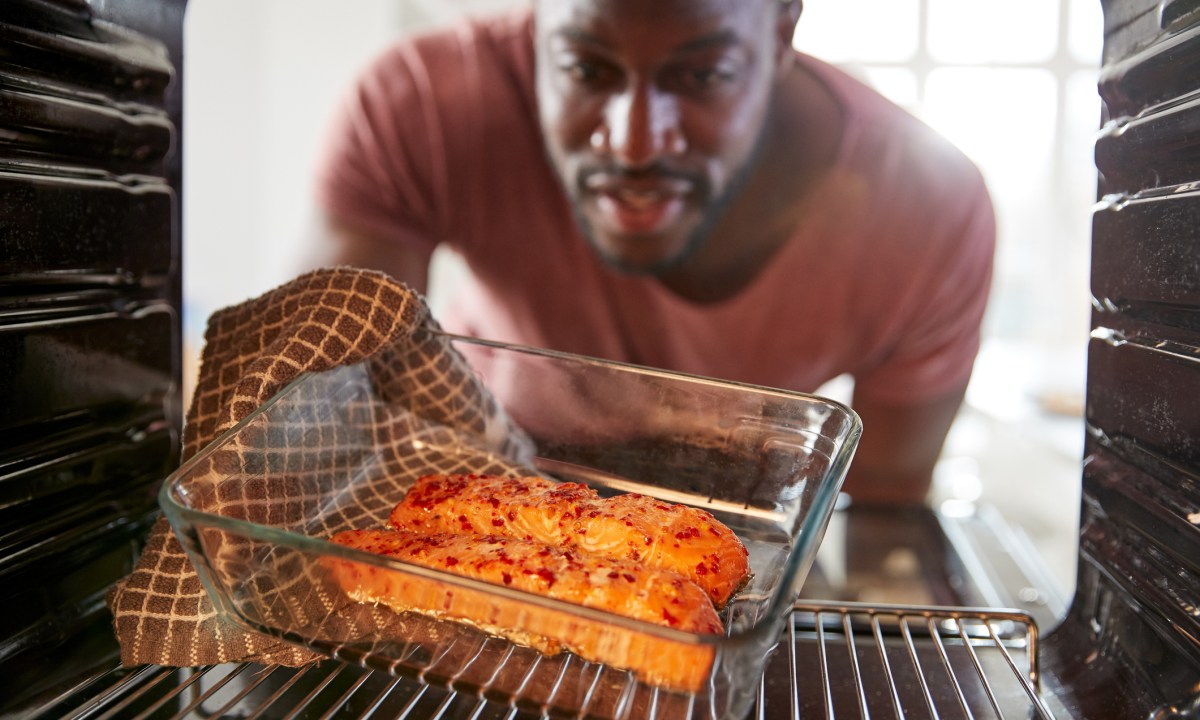 View looking out from Inside oven as man cooks oven-baked salmon