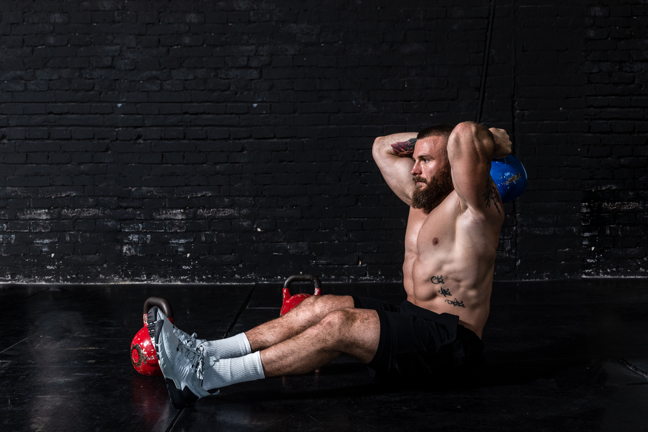 Man sitting on the ground working out.