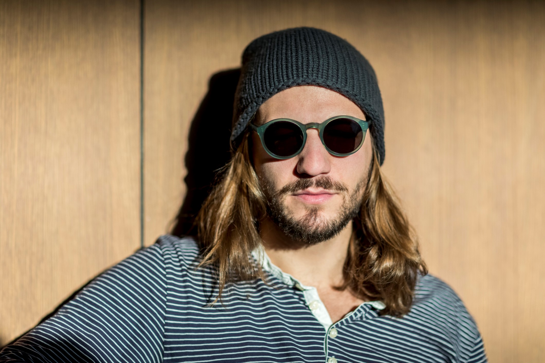 A man with long hair wearing a beanie.
