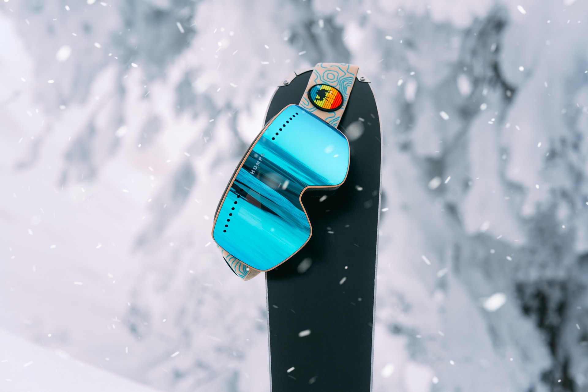 Ski goggles hanging on a snowboard