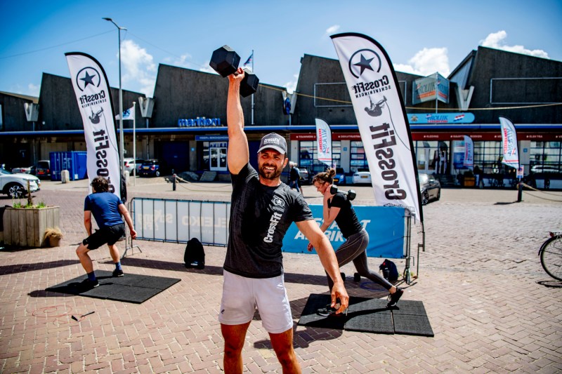 A man using a dumbbell in a CrossFit workout.