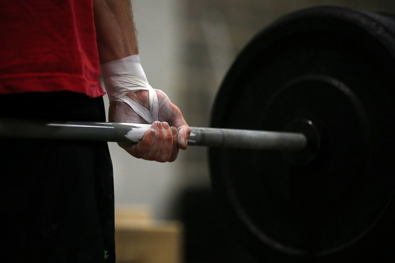 hand of a man holding a weights.