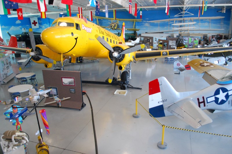 A large, yellow, twin propellor airplane, inside the Fargo Air museum.