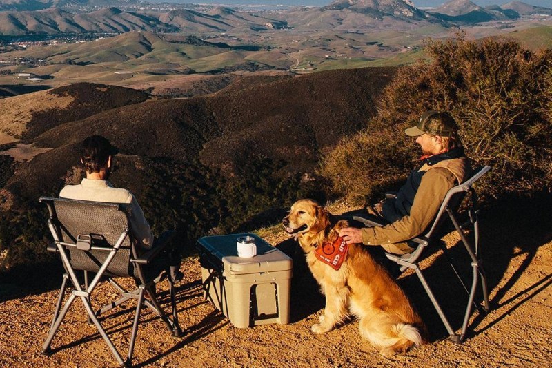 two men with a yeti cooler and a dog