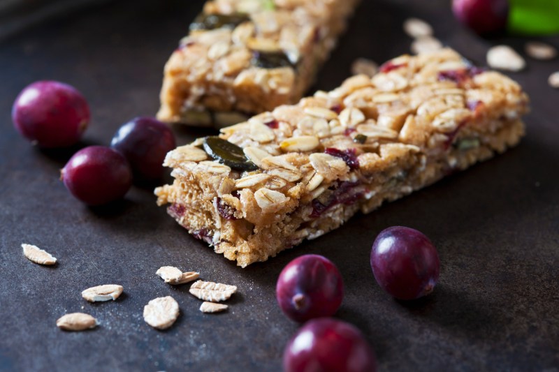 Closeup of a fruit granola bar on a dark surface.
