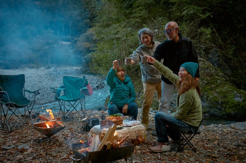 A family having a toast around a campfire.
