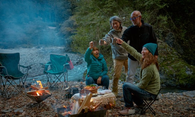 best camping dishes and utensils on amazon senior couples barbecuing at riverside campsite with sustainability