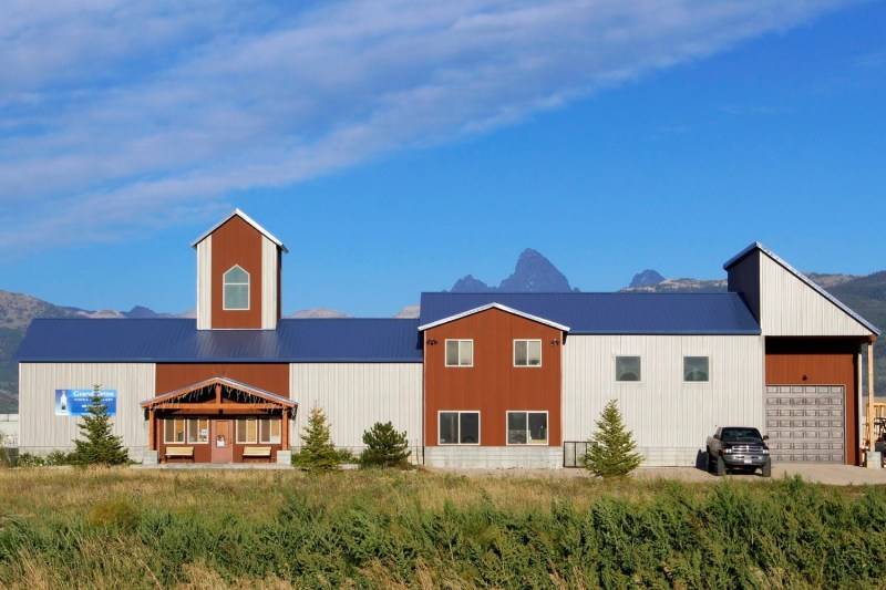 The front of Grand Teton Distillery with the mountains just peeking over the roof.