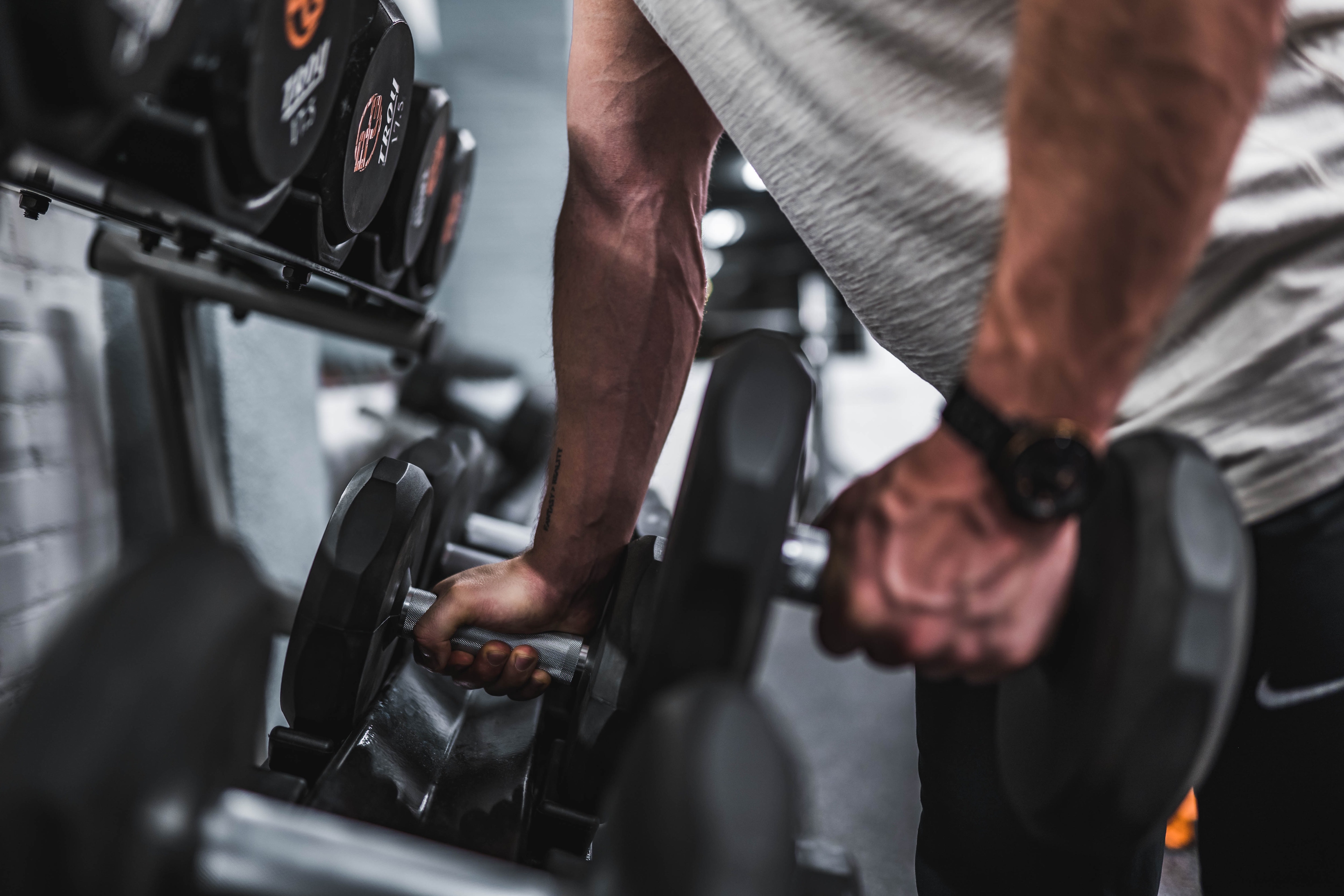 A man picking up a set of dumbbells.